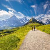 © gevisio - Shutterstock - Jeune couple randonnant de Kleine Scheidegg, Monch and Jungfrau, Berner Oberland, Grindelwald, Suisse. hiking bernese oberland
