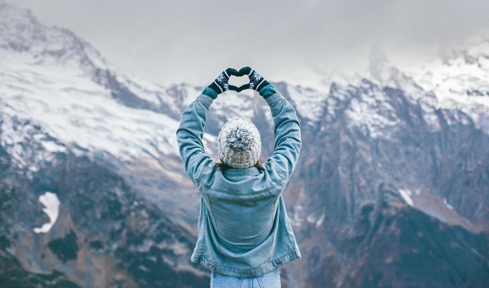 Ozerova - Alena - AdobeStock - Femme formant un cur avec ses mains devant une chaîne de montagne, hiver, Alpes Sur mesure