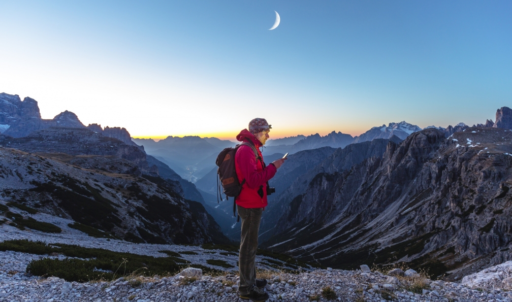 deimagine -  istock -  Randonneur en montagne regardant son téléphone portable, France