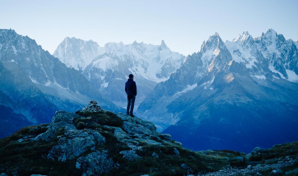 SanderStock -  Istock -  Homem face à la chaîne du Mont-Blanc, Alpes, France - Best of the classic walks around the Mont Blanc - 1 french-alps-best-of-the-classic-walks-around-the-mont-blanc-1