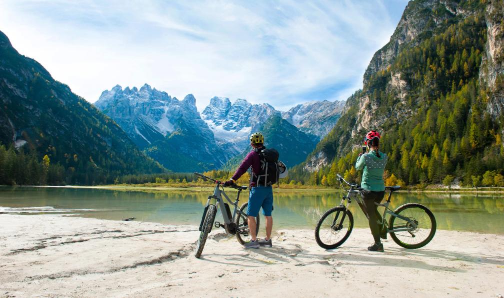 evgeny - Adobe stock - Cyclistes devant un lac admirant le paysage dans les Dolomites, Alpes, Italie - Cycling in the Dolomites dolomites-cycling-through-meadows-and-lakes