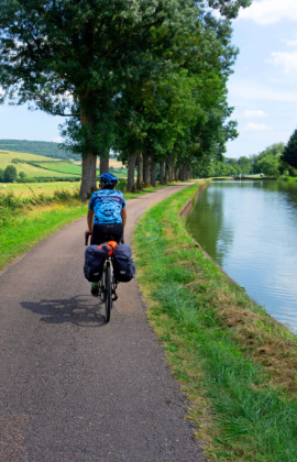 Cycliste le long du Canal de Bourgogne dominé par le Château de Chateauneuf, Bourgogne, France