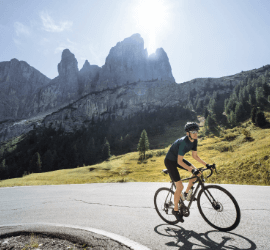 Cycliste sur route gravissant un col dans les Dolomites, Italie